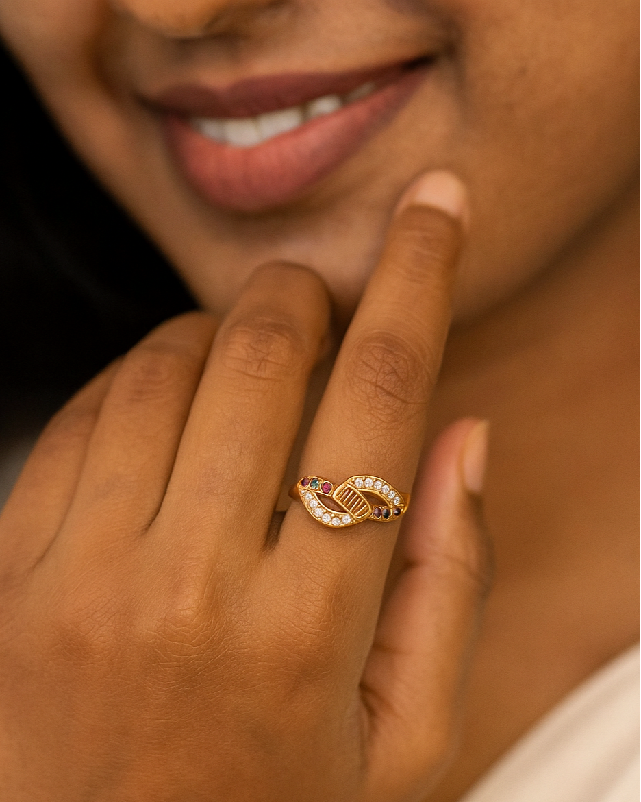 Close-up of a hand wearing a gold ring with a diamond, touching the face.