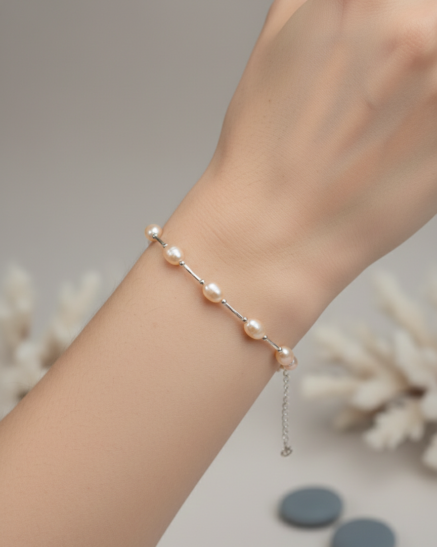 Pearl bracelet on a wrist with a neutral background