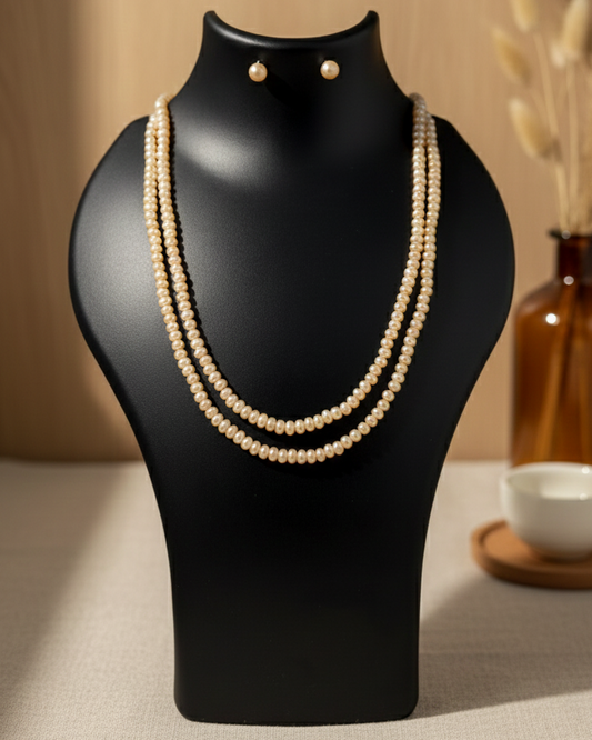 Pearl necklace on a black mannequin bust with a blurred background