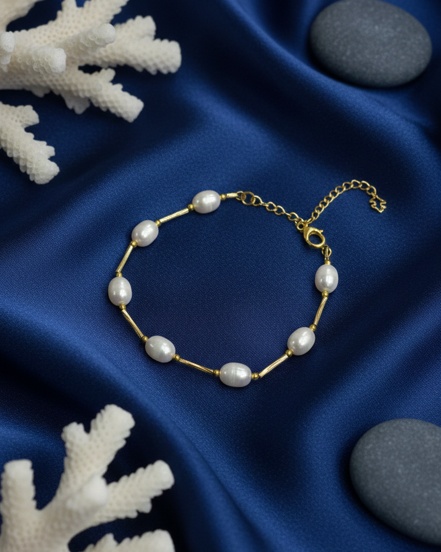 Pearl bracelet on a blue satin fabric with white coral and gray stones