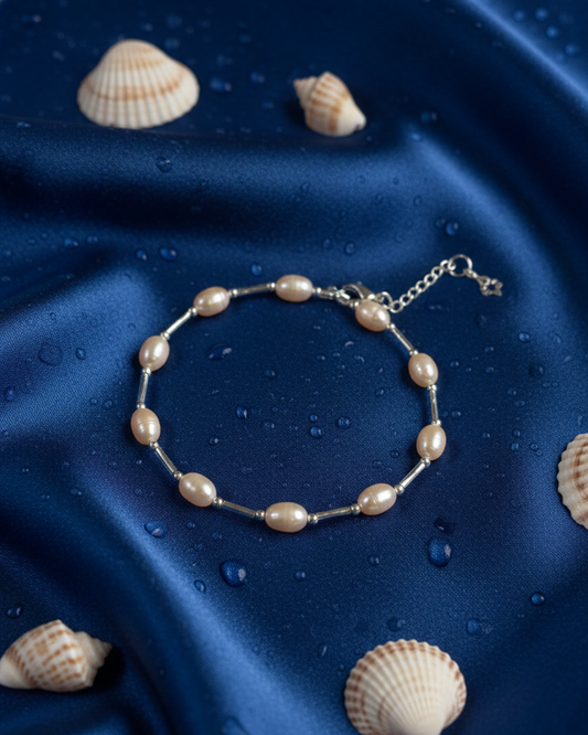 Pearl bracelet on a blue satin surface with seashells