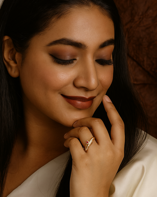Woman with a soft smile, wearing a ring, against a warm brown background