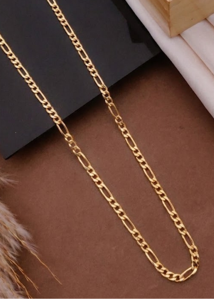 Gold chain on a textured surface with a wooden frame in the background