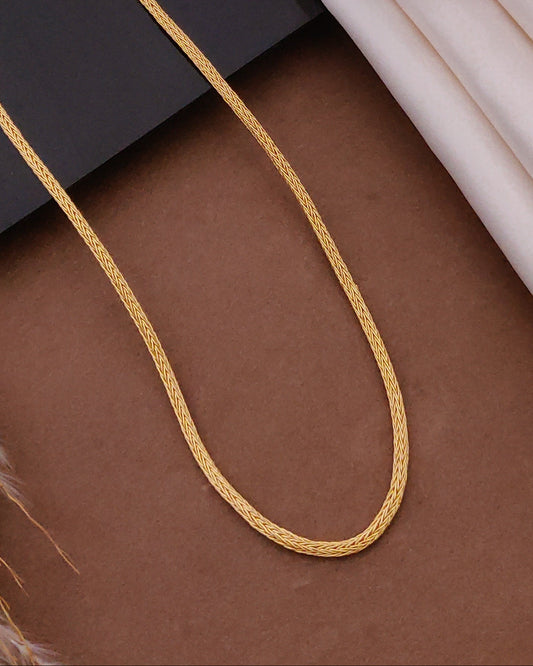 Gold chain on a surface with picture frames in the background