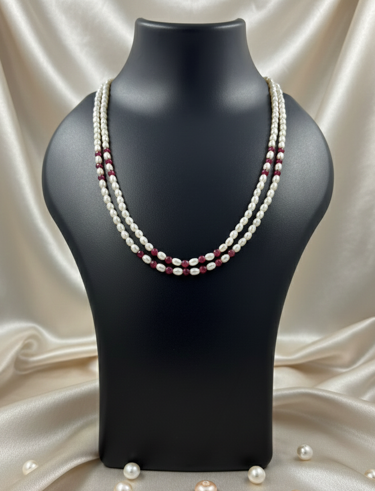 Pearl necklace on a black mannequin bust with a beige fabric background
