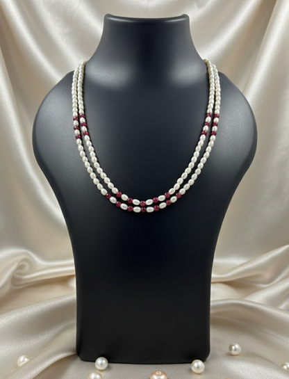 Pearl necklace on a black mannequin bust with a beige fabric background