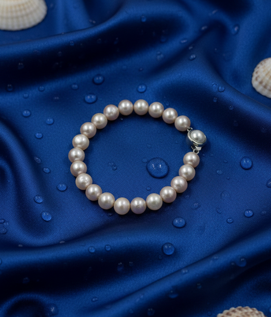 Pearl bracelet on a blue fabric background with shells